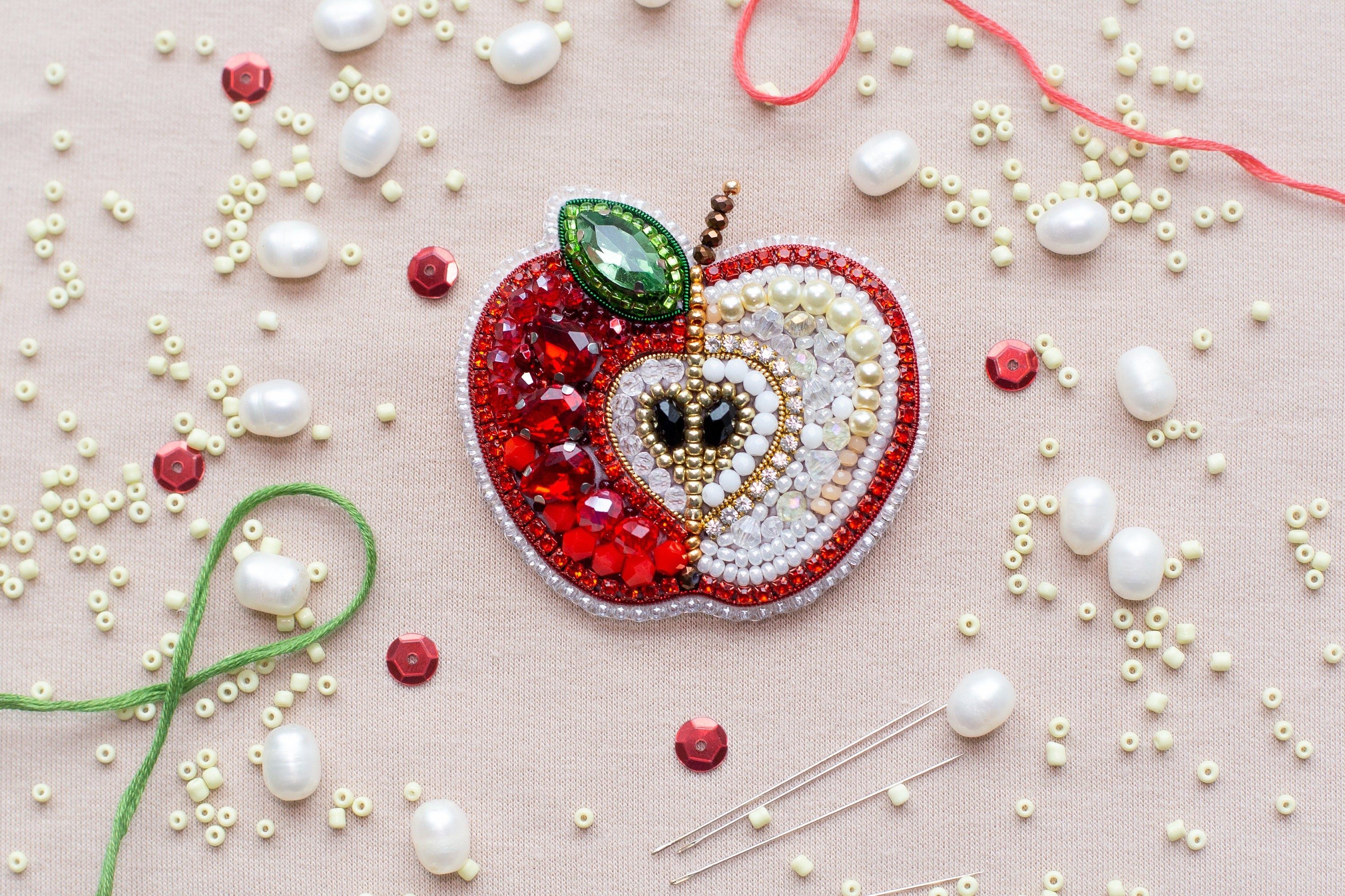 a beaded apple with a green leaf on top of it